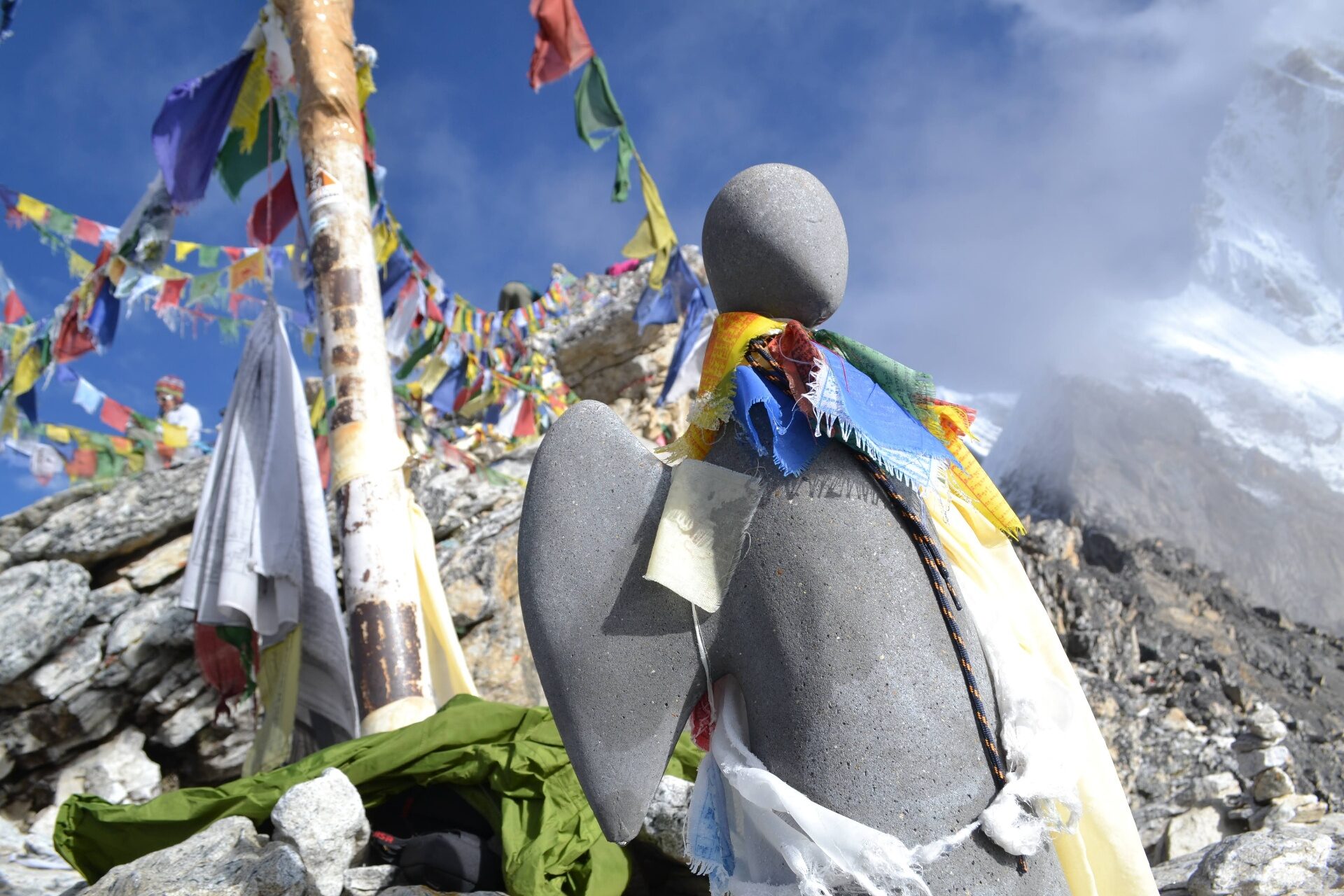 A stone cairn wrapped in Tibetan prayer flags in the Everest region of Nepal — alignment held together at altitude