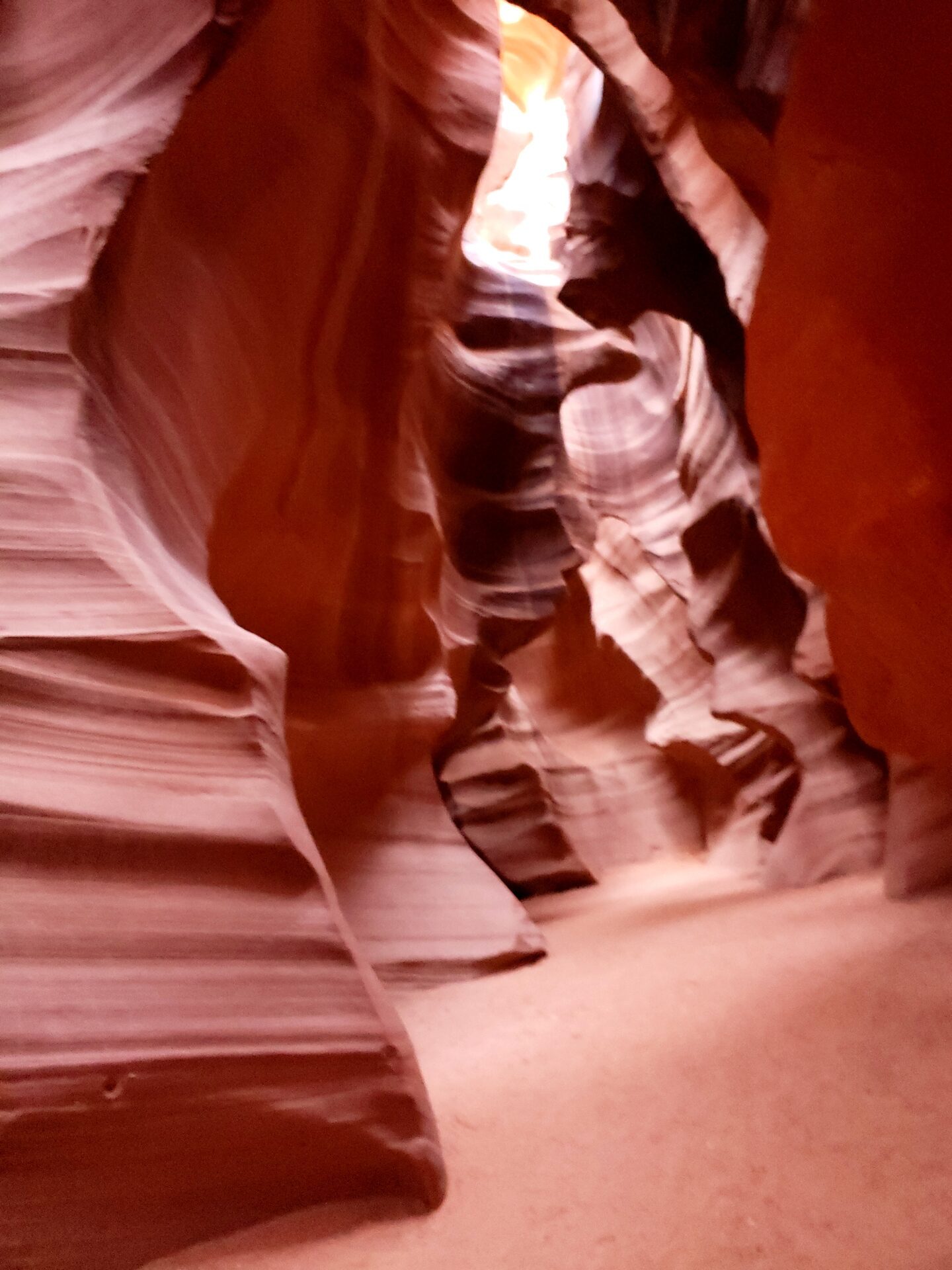 Sandstone canyon corridor with a soft sandy path curving between the walls, Antelope Canyon, Arizona